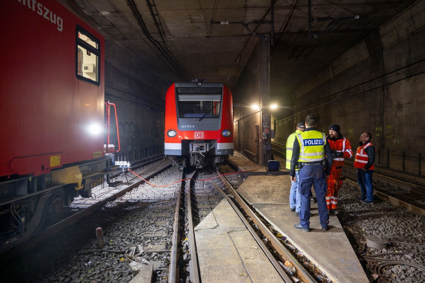 Bundespolizisten und Bahnarbeiter stehen in den Morgenstunden an der entgleisten S-Bahn im Tunnel hinter der Haltestelle Isartor.