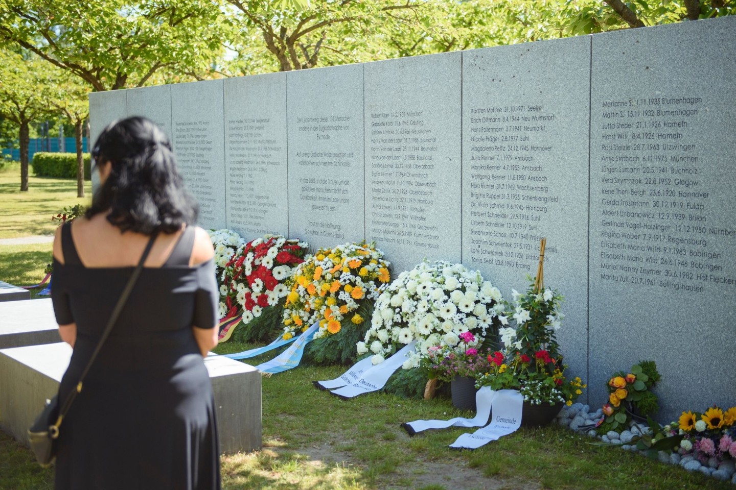 Eine Frau steht am 25. Jahrestag in der Gedenkstätte vor der Gedenktafel der Opfer des ICE-Unglücks von Eschede.