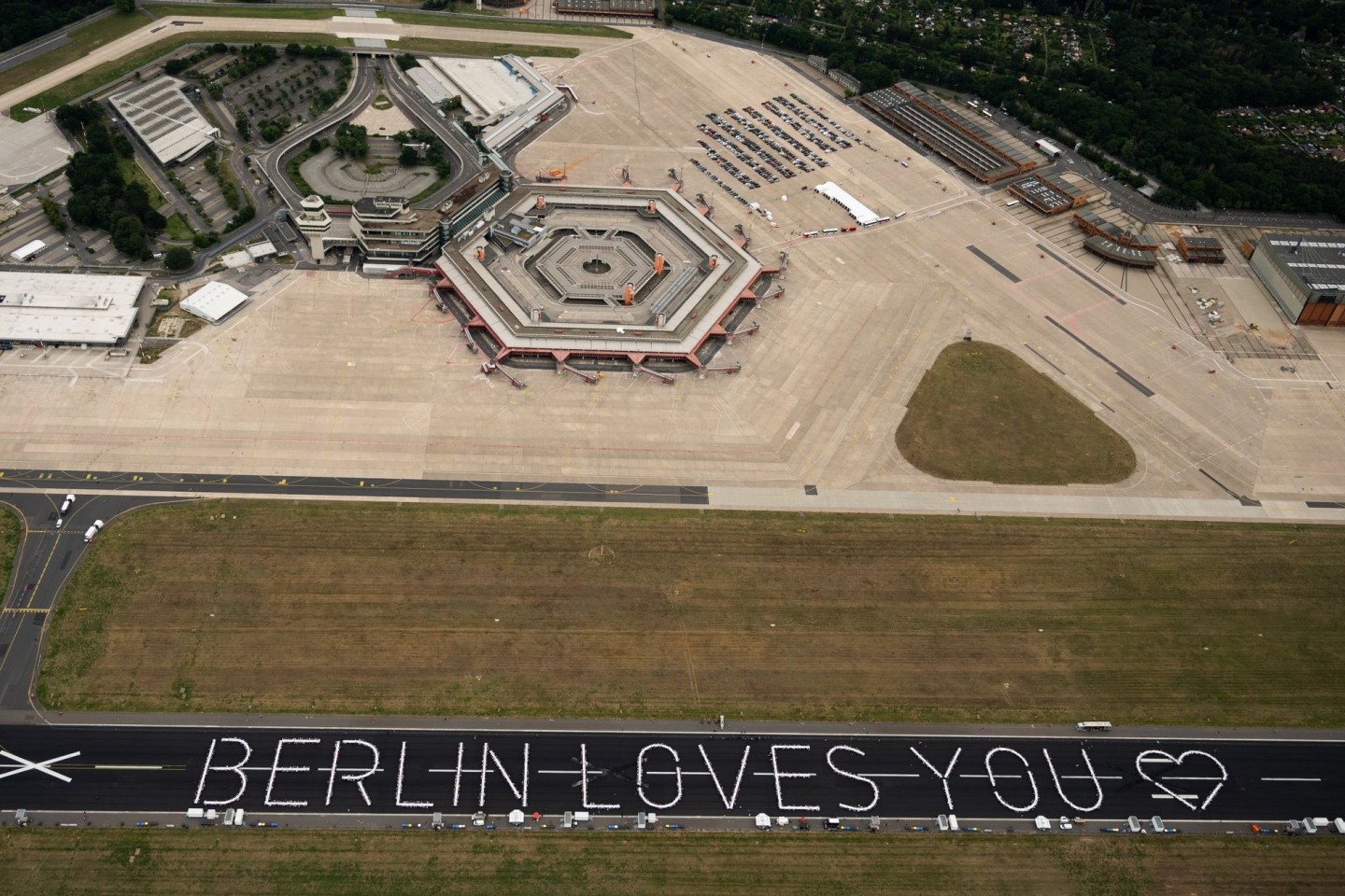 Tische bilden auf der Startbahn des ehemaligen Berliner Flughafens Tegel den Schriftzug «Berlin loves you».