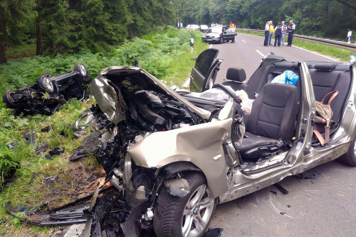 Zwei vollkommen zerstörte Autos liegen nach dem Unfall am Rand der Landstraße L12 zwischen Roetgen und Simmerath in der Eifel. (Archivbild)