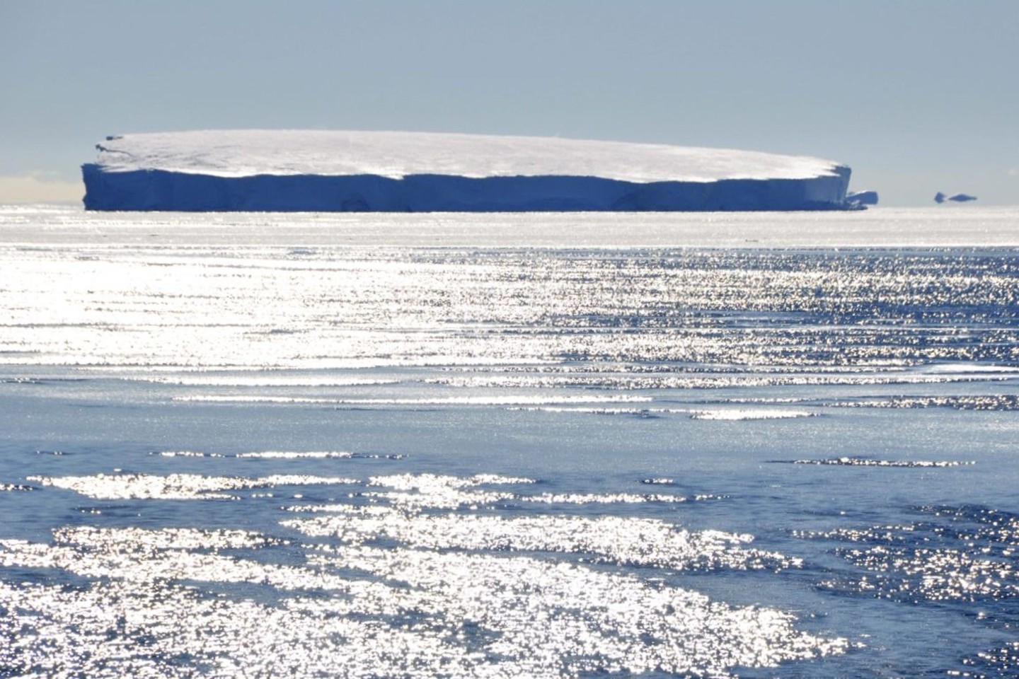 Eisschollen treiben in der Antarktis vor einem Eisberg. Das Eis dehnt sich immer weniger aus.