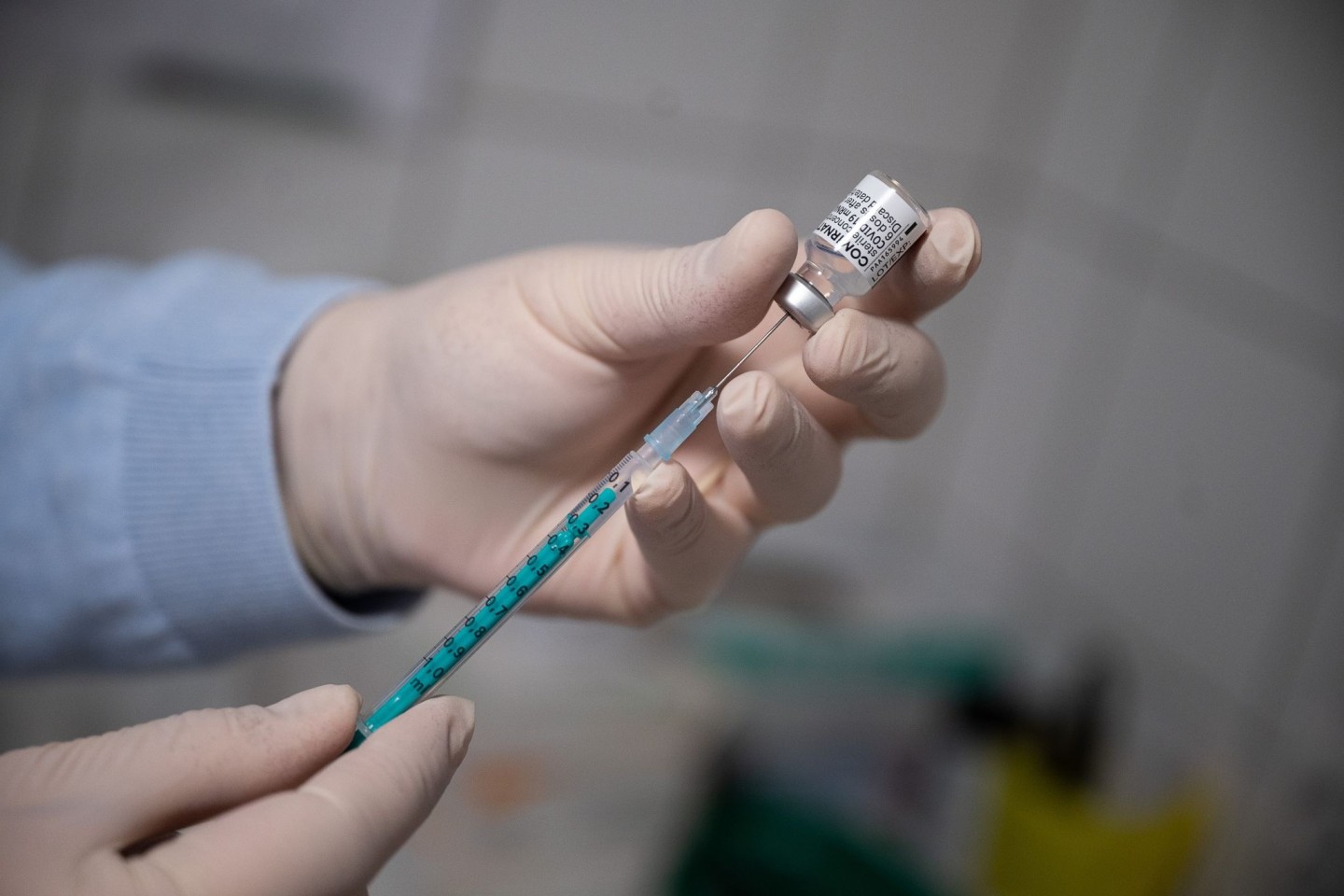 Ein Arzt zieht eine Spritze mit dem Impfstoff von Pfizer/Biontech auf.