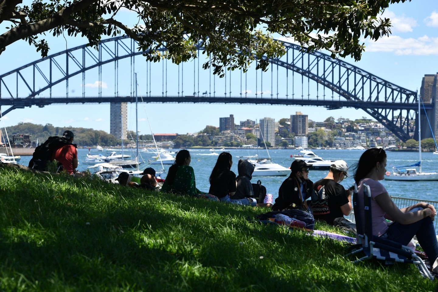 Vor den Silvesterfeierlichkeiten in Sydney versammelt sich eine kleine Menschenmenge an einem Aussichtspunkt mit Blick auf die Harbour Bridge.