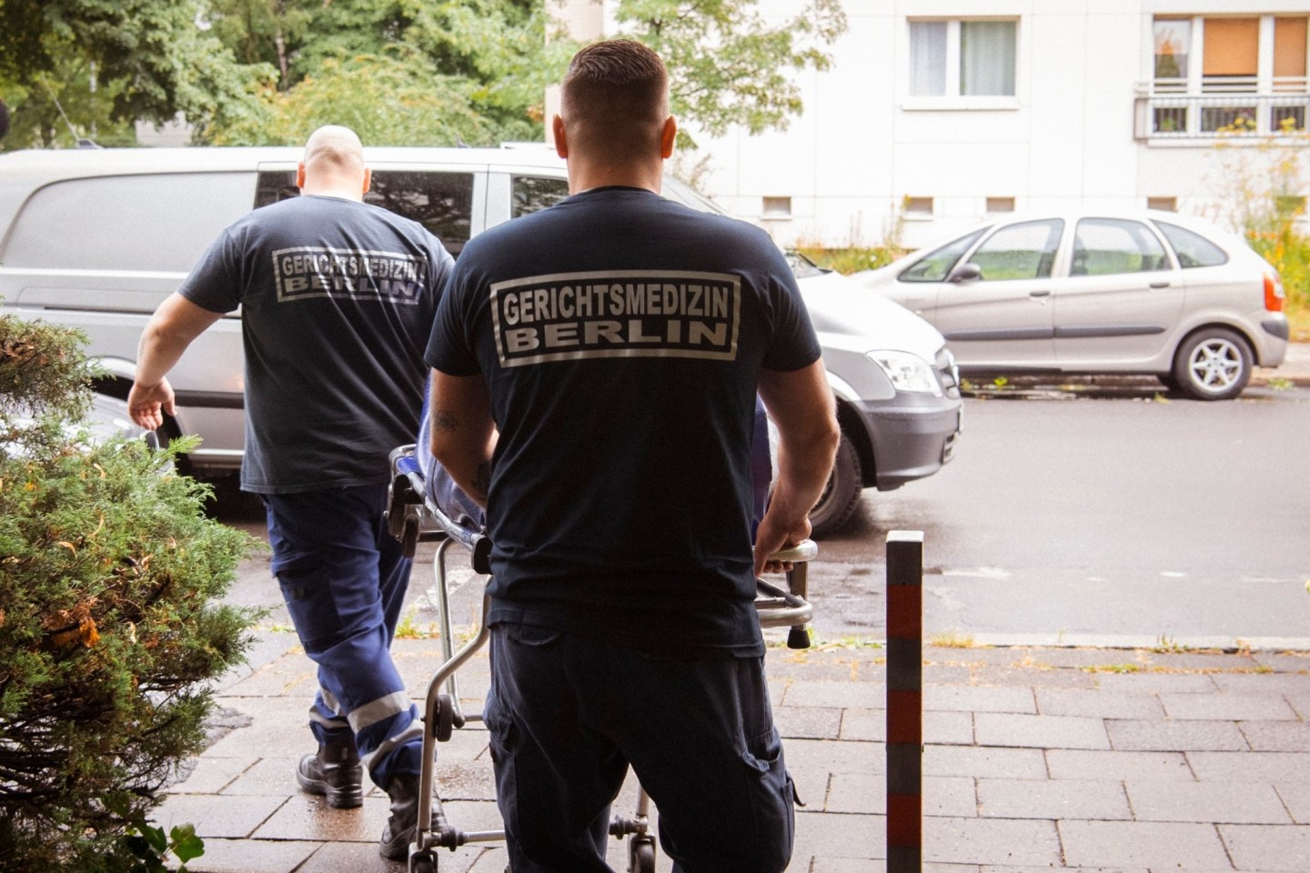 Mitarbeiter der Gerichtsmedizin transportieren die Leiche aus einer Wohnung in einem Mehrfamilienhaus in der Berliner Singerstraße zu ihrem Fahrzeug.