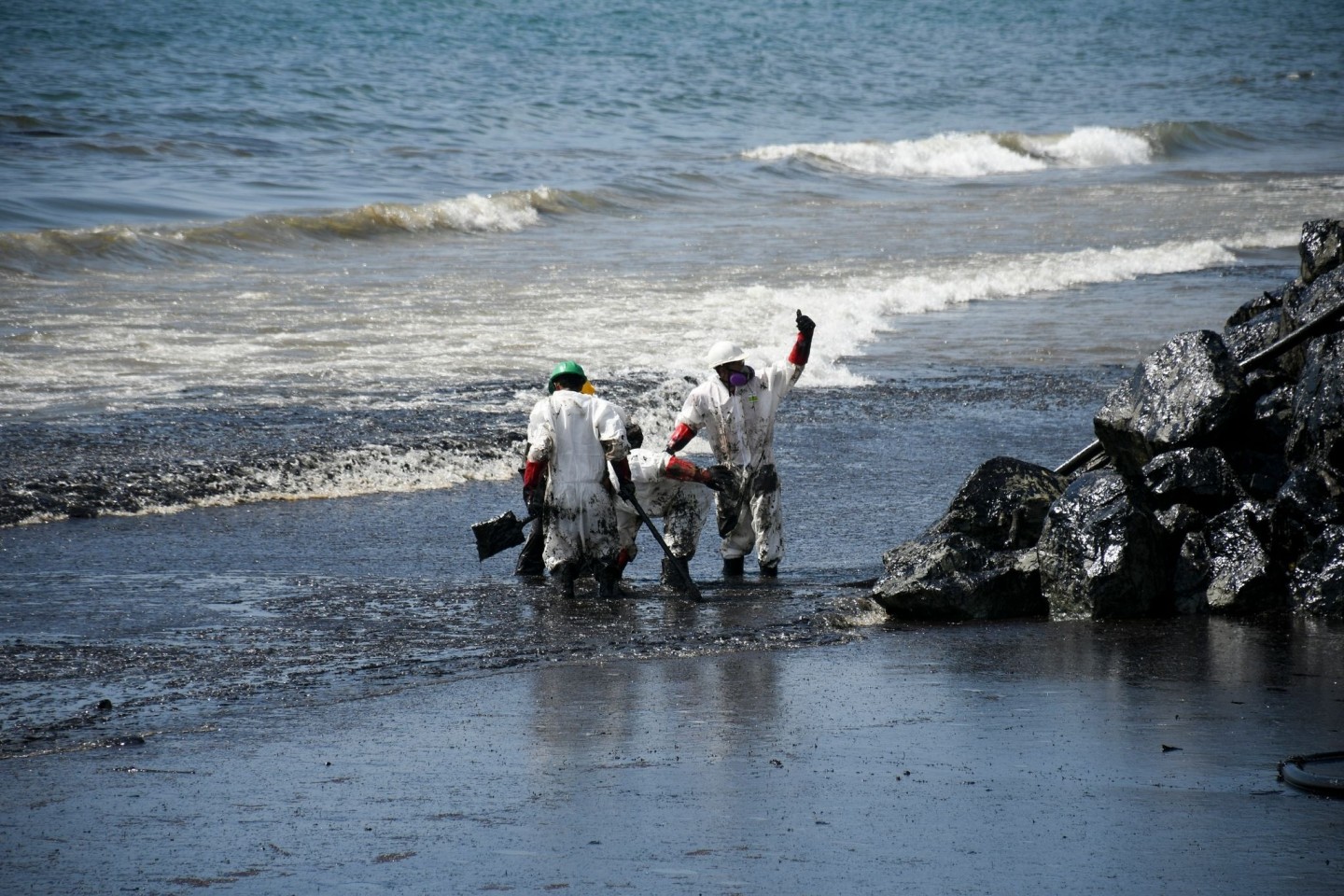 Arbeiter beseitigen einen Ölteppich, der den Strand von Rockly Bay in Scarborough im Südwesten Tobagos erreicht hat.