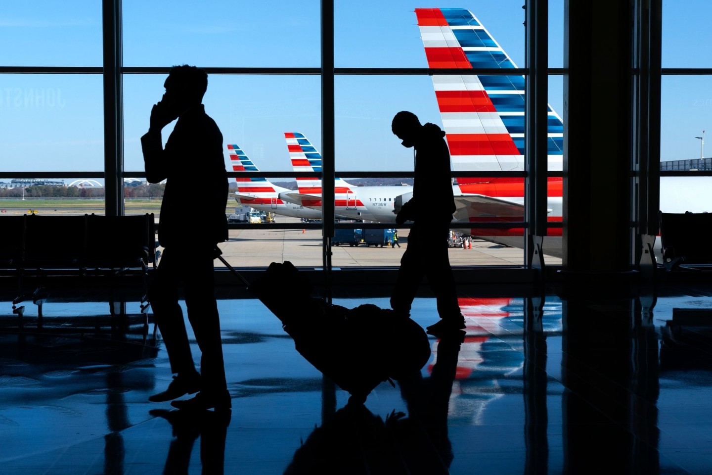 Flugreisende am Ronald Reagan Washington National Airport - im Hintergrund: Maschinen der Fluggesellschaft American Airlines.