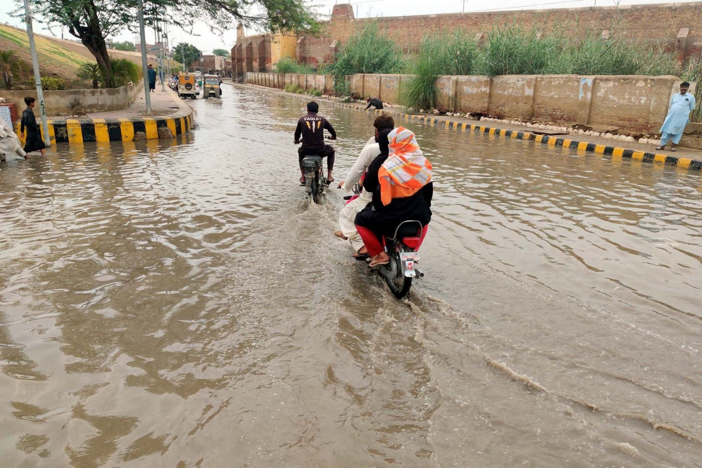 Überall Wasser: Menschen fahren in Sukkur nach starkem Monsunregen durch überschwemmte Straßen.