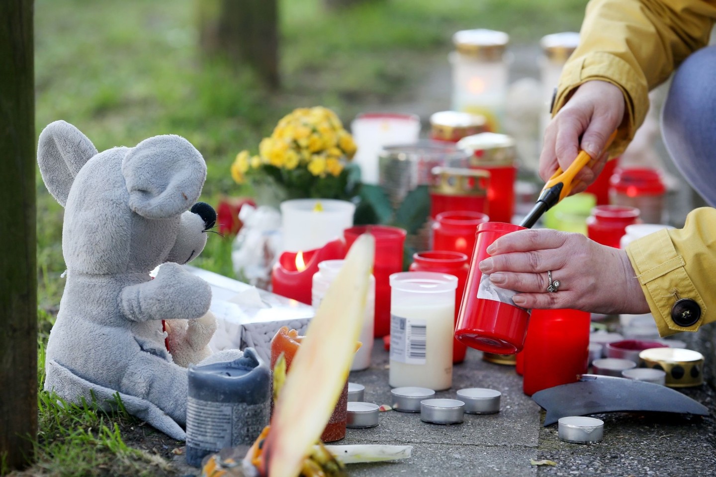Eine Anwohnerin zündet am Parkhaus eine Kerze für die toten Teenager an.