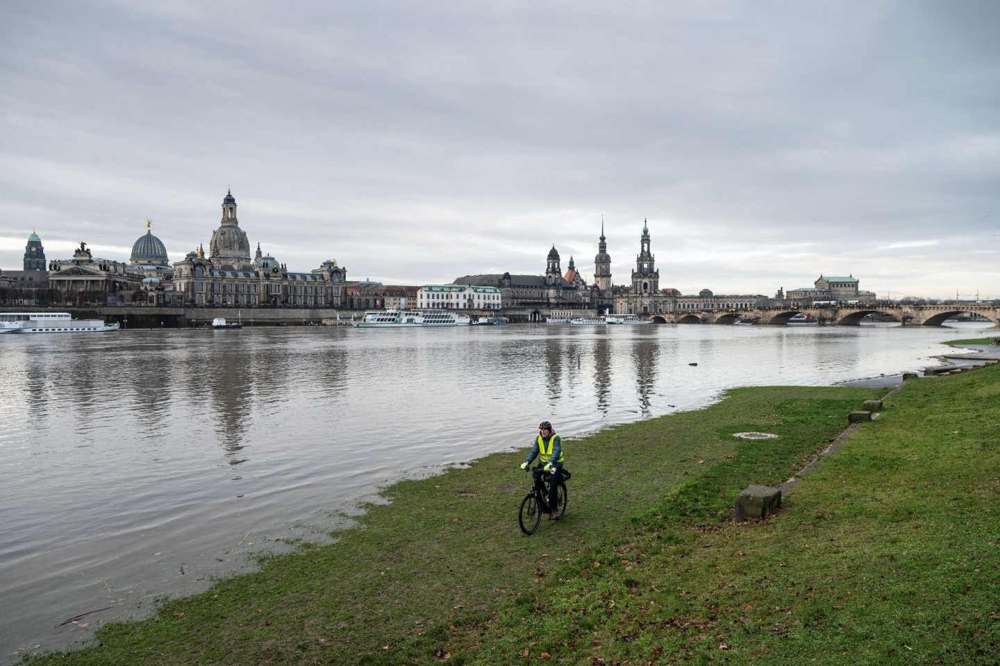 Ein Mann fährt mit seinem Fahrrad über die vom Hochwasser überfluteten Elbwiesen am Königsufer in Dresden.